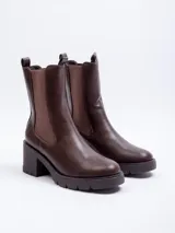 Bota de caña alta de símil cuero color verde oscuro, con plataforma de 7 cm y detalles elásticos en los laterales.