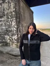 Campera negra de lana con frente de cuero, cierre frontal con cremallera y mangas largas.