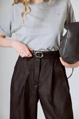 Pantalón negro de corte ancho y tiro alto, con pinzas en la cintura y bolsillos laterales.