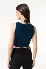 Top de lurex negro elastizado con aberturas en el frente y escote pronunciado, con ajuste en el cuello.