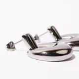 Par de aros colgantes plateados con forma de medialuna gruesa.
