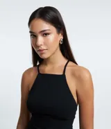 Enterito corto de bengalina color negro, con escote halter, espalda descubierta y tirantes finos cruzados. Presenta corte short pollera.
