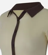 Blusa color amarillo claro confeccionada en tejido rib, con cuello polo marrón, manga corta y cierre frontal con botones marrones.