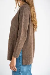 Sweater color beige de tejido texturado, con cuello redondo y mangas largas.