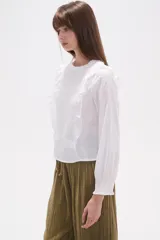 Blusa de algodón color negro con cuello a la base y detalle de volados en el frente. Posee mangas largas con puños elásticos y un panel frontal con textura fruncida.