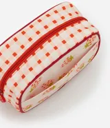 Neceser rectangular mediano de poliéster con estampado de frutillas y diseño a cuadros en los laterales. Tiene cierre de cremallera con llavero en forma de frutilla y ribete rojo.