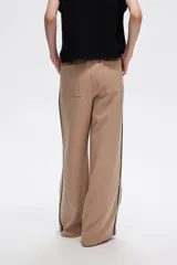 Pantalón negro ancho de viscosa con vivos laterales en blanco, dorado y marrón.