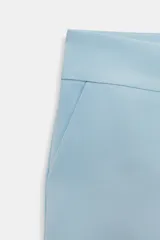 Shorts de tiro medio color negro, con bolsillos delanteros y falsos bolsillos con solapa en la parte trasera. Cierre frontal con cremallera y ganchos metálicos.