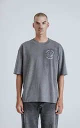 Remera gris melange de manga corta con cuello redondo y calce oversize. Estampado en el frente con una ilustración de una figura femenina y la inscripción "El Mundo".