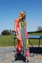 Túnica estampada multicolor con diseño de bloques con motivos ecuestres y geométricos. Tiene cuello camisero, mangas cortas y calce holgado.