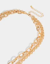 Set de tres collares dorados de diferentes largos, con eslabones de distintos tamaños. Incluye un dije de corazón y un dije de llave.