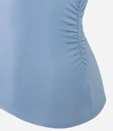 Top sin mangas de color celeste claro, ajustado al cuerpo, con cuello alto y detalle de drapeado cruzado en el área del busto y frunces laterales.