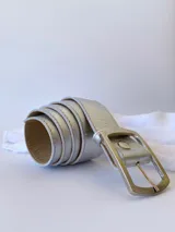 Cinto plateado de cuero con hebilla rectangular plateada.