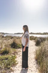 Blusa blanca de algodón con bordados florales en azul marino en el frente y las mangas.