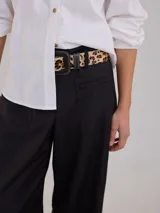Pantalón negro de tiro medio alto con pretina elastizada en la espalda, pierna ancha y bolsillos plaque en delantera y espalda.