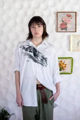 Camisa de algodón satinado blanca con estampado gráfico en el frente y manga larga con puños.