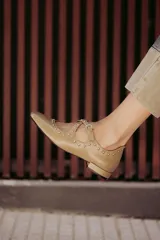 Zapatos tipo Mary Jane con silueta femenina, detalles de tachas metálicas y taco bajo, que aportan comodidad y un toque elegante.