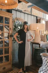 Vestido largo de tejido acanalado, con diseño bicolor vertical: mitad negro y mitad beige claro. Tiene mangas cortas y escote en V.