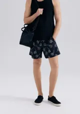 Short de baño blanco con estampado de hojas negras.