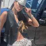 Chaleco negro de cuero ovino con cuello en V y cierre frontal con botones.