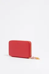 Billetera roja con exterior de piel y estructura rígida. Incluye cierre con cremallera, tirador de cordón, bolsillo interior con cierre de cremallera y logo grabado.