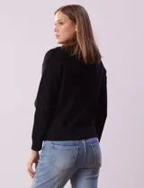Cárdigan tejido negro con cuello con solapa y abertura central con cierre. Delantera con bolsillos simulados.