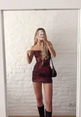 Vestido corto marrón con estampado animal print, corte ajustado, escote strapless con aberturas en el frente y breteles finos.