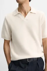 Polo color crema de punto con cuello solapa y abertura frontal en V.