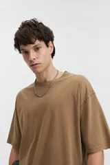 Remera de manga corta color marrón claro, de corte amplio y cuello redondo.