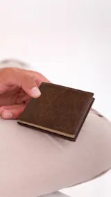 Billetera de cuero marrón con ribete beige y costuras a la vista. Interior con compartimento para billetes, visor y capacidad para cinco tarjetas.