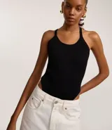 Body negro de tejido acanalado, con escote redondo y tirantes finos que se cruzan en la espalda.