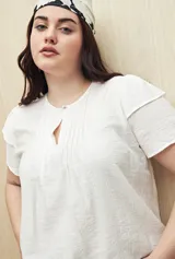 Blusa blanca de tela liviana con mangas cortas con volados y botón de nácar.