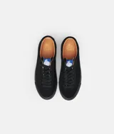 Zapatillas bajas de gamuza negra con suela y cordones negros.