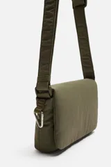 Bandolera negra de nylon con solapa y cierre magnético. Tiene correa ajustable con mosquetón y bolsillo interior.