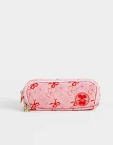 Cartuchera rosa claro con estampado de moños rojos y logo de cerezas. Tiene tres divisiones internas con cierre y tiracierre de moñitos.