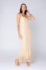 Vestido largo color beige con textura geométrica, breteles finos y escote con nudo. Posee flecos en el ruedo.
