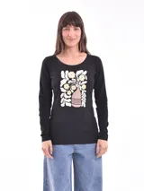 Remera negra de manga larga con cuello redondo y estampado de flores y hojas en colores blanco, amarillo y rosa.
