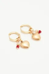 Aros dorados tipo argolla con dije de corazón en metal y piedras facetadas rojas.
