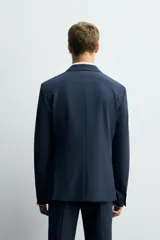 Blazer slim fit azul marino confeccionado en tejido con viscosa. Cuello con solapas de muesca, manga larga con puño abotonado, bolsillo de vivo en pecho y de solapa en cadera, bolsillo interior, bajo con aberturas en espalda y cierre frontal con botones.