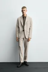 Blazer slim fit color beige confeccionada en tejido con viscosa. Cuello con solapas de muesca, manga larga acabada en puño con detalle de botones, bolsillo de vivo en pecho y de solapa en cadera, detalle bolsillo interior, bajo con aberturas en espalda y cierre frontal con botones.