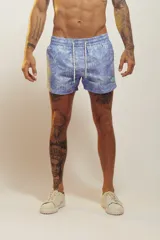 Short de baño celeste con estampado de hojas de palmera en blanco.