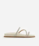 Sandalia plana mule color crema con punta redonda y tiras finas con brillos.