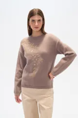 Sweater color lila con apliques de lentejuelas doradas formando un diseño floral en el frente.