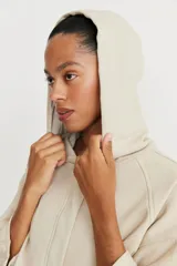 Campera color beige de mangas 3/4 con capucha y cierre frontal.