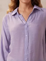 Camisa color beige claro, de corte recto y mangas 3/4 con botón para sujetar.