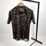 Camisa de algodón con estampado en tonos marrón y tierra, con cuello mao y manga corta.
