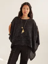 Poncho liviano color negro con brillo sutil y corte asimétrico, diseñado para aportar elegancia.