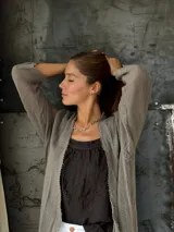 Saco de hilo color beige, de manga larga y tejido calado.