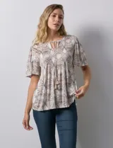 Blusa de tejido elastizado con estampado geométrico en tonos beige y blanco. Tiene cuello redondo con escote en V y lazo de ajuste, y mangas cortas amplias. Marca Cupio.