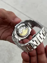 Reloj de pulsera Patek Philippe Nautilus con caja y brazalete de acero inoxidable, esfera azul con patrón horizontal en relieve y movimiento automático.